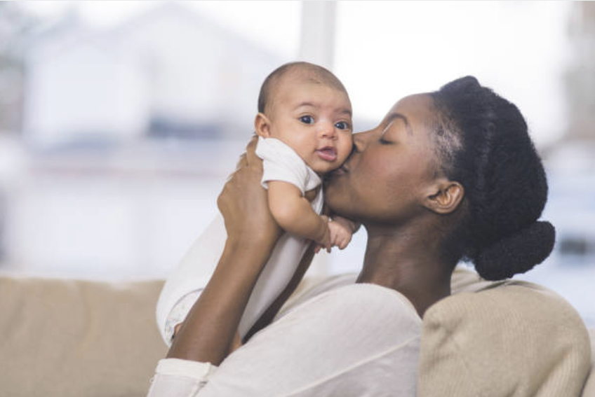 Loving Mother kisses her child